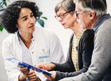 A specialty pharmacy patient and her spouse talk with a doctor