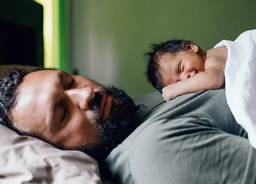 A specialty pharmacy patient sleeping as his infant child sleeps on his chest