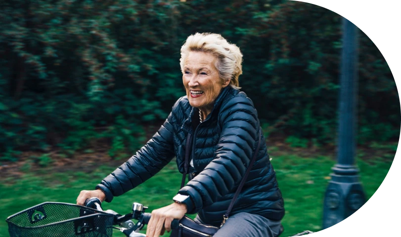An elderly specialty patient enjoying a bike ride on a cool, breezy day