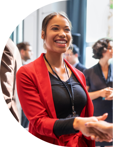 A smiling young professional shaking someone's hand in a meeting