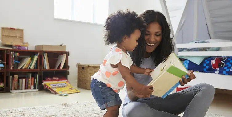 A specialty pharmacy patient and her toddler child read a picture book together