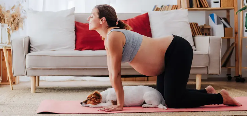 A specialty pharmacy patient doing yoga while her dog sleeps nearby